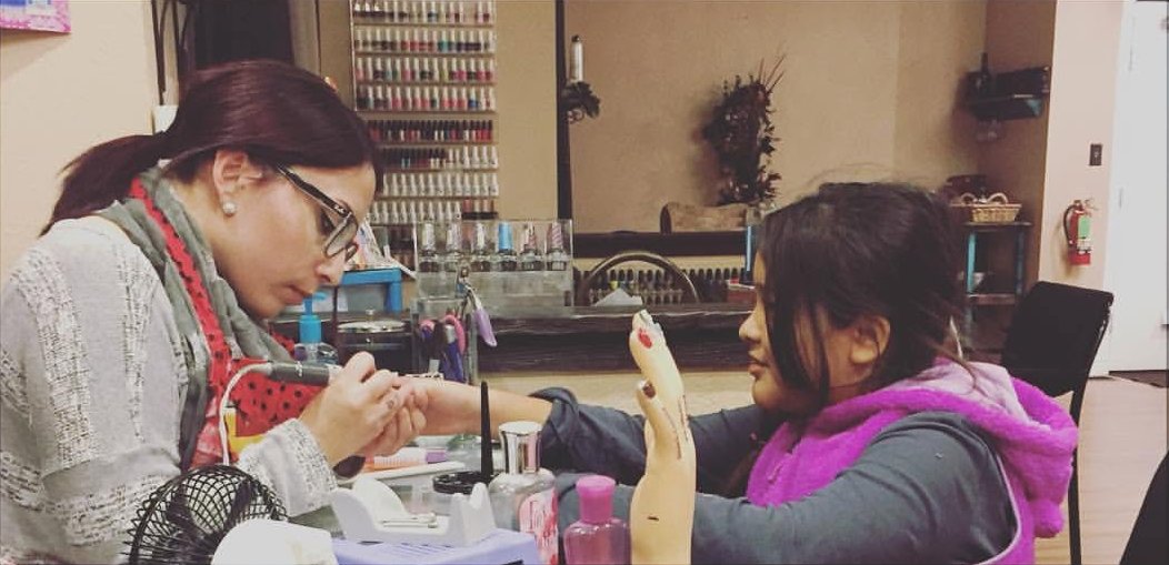 Jennifer at her table at Salon on the Square, working on a client's nails.